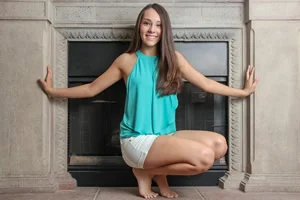 Portrait Of A Female High School Senior In Front Of A Fireplace